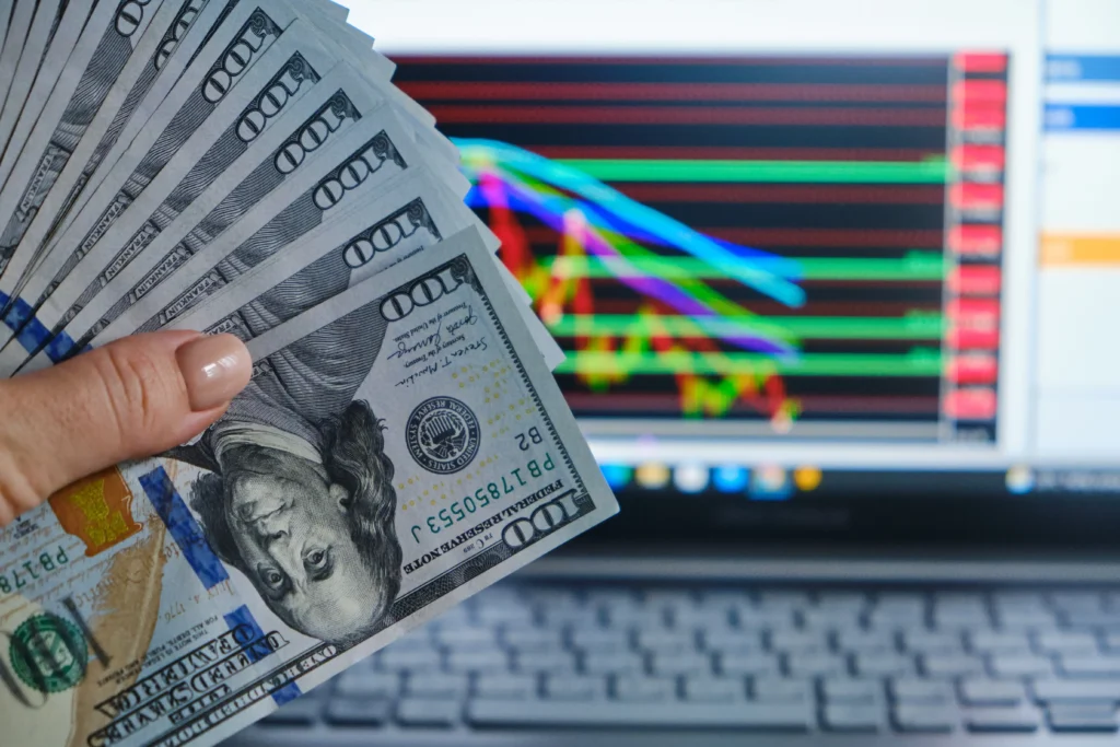 Are Forex Signals Still Profitable in 2025 as traders hold US dollars against forex charts with high-frequency signals displayed.