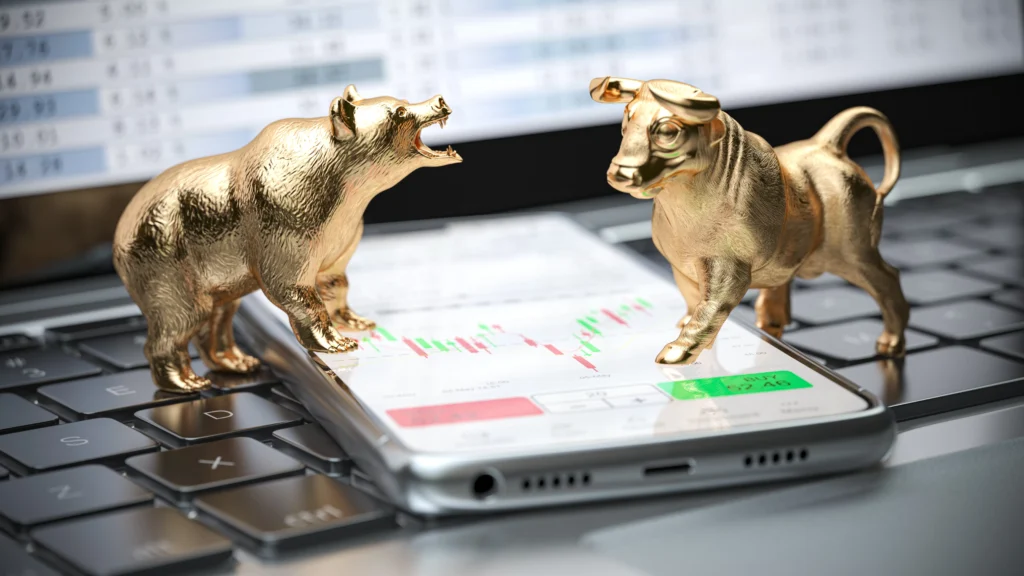 Golden bull and bear on stock chart symbolizing market trends.