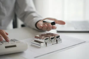 Investor analyzing silver bars and market data to plan silver investment strategy in 2025.