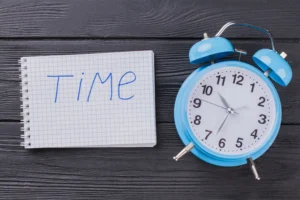 Clock and notepad symbolizing the best time to trade Forex in 2025.