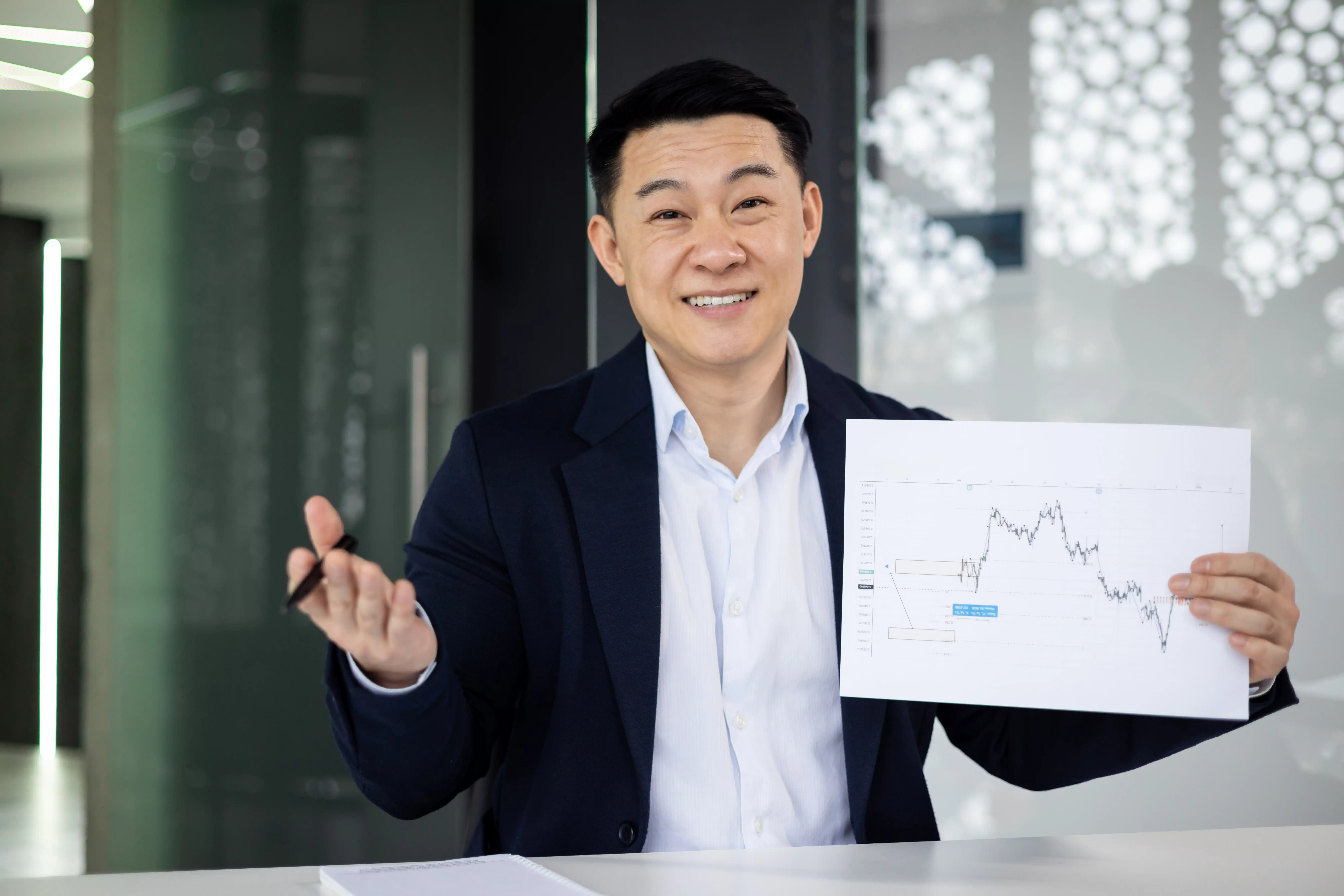 Professional trader showing a printed price chart while explaining market structure and trading concepts related to the Donchian Channel.