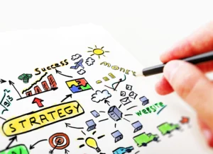 A person drawing a colorful business strategy plan with illustrations of money, success, and growth.