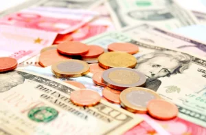 Euro coins and dollar banknotes scattered together.