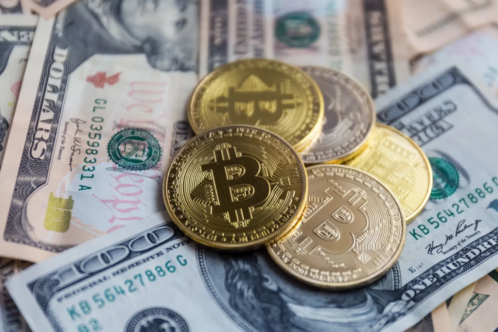Golden Bitcoin coins placed over US dollar bills symbolizing digital currencies in forex markets.