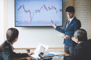 Business team analyzing Ichimoku Cloud Indicator chart showing Kumo Cloud, Tenkan-sen, and Kijun-sen signals on a large display.
