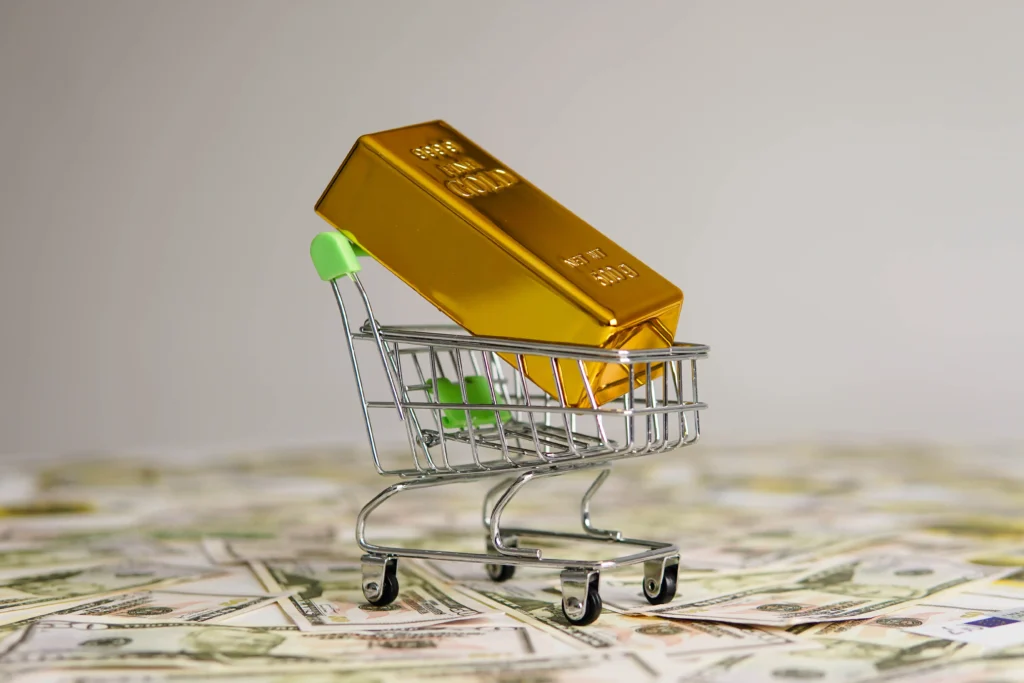 Gold bar placed in a small shopping cart symbolizing gold’s value as a safe-haven asset.