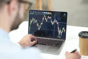 Trader analyzing currency charts on a laptop while reviewing Swap Rates and market movements.